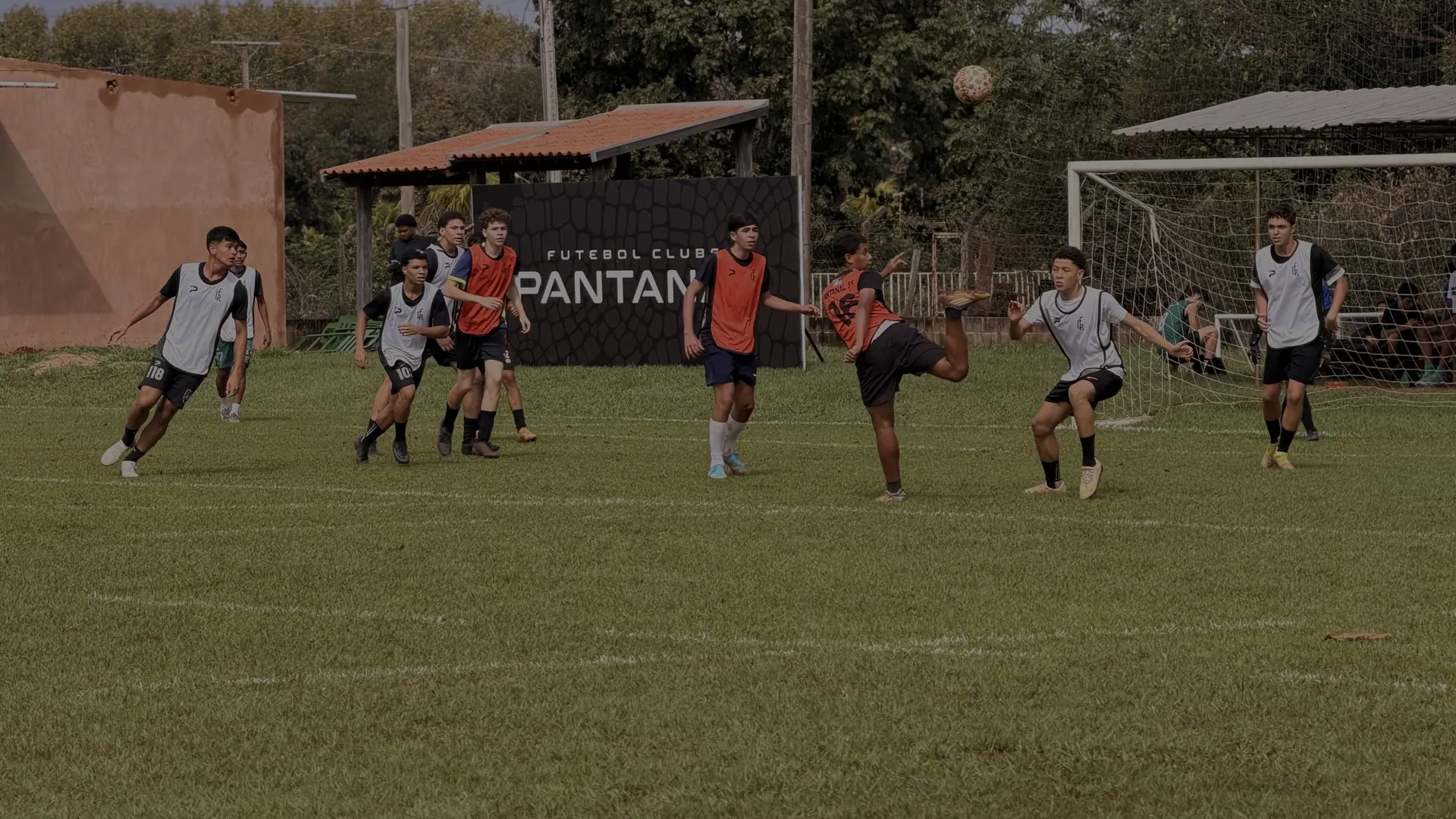 Jogo do Pantanal no campo do clube, com o painel da marca ao fundo
