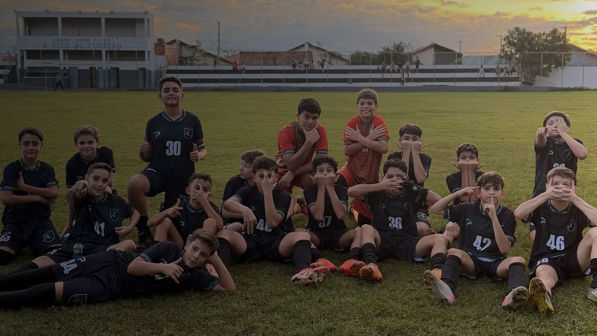Time do Pantanal sentado no gramado no fim da tarde