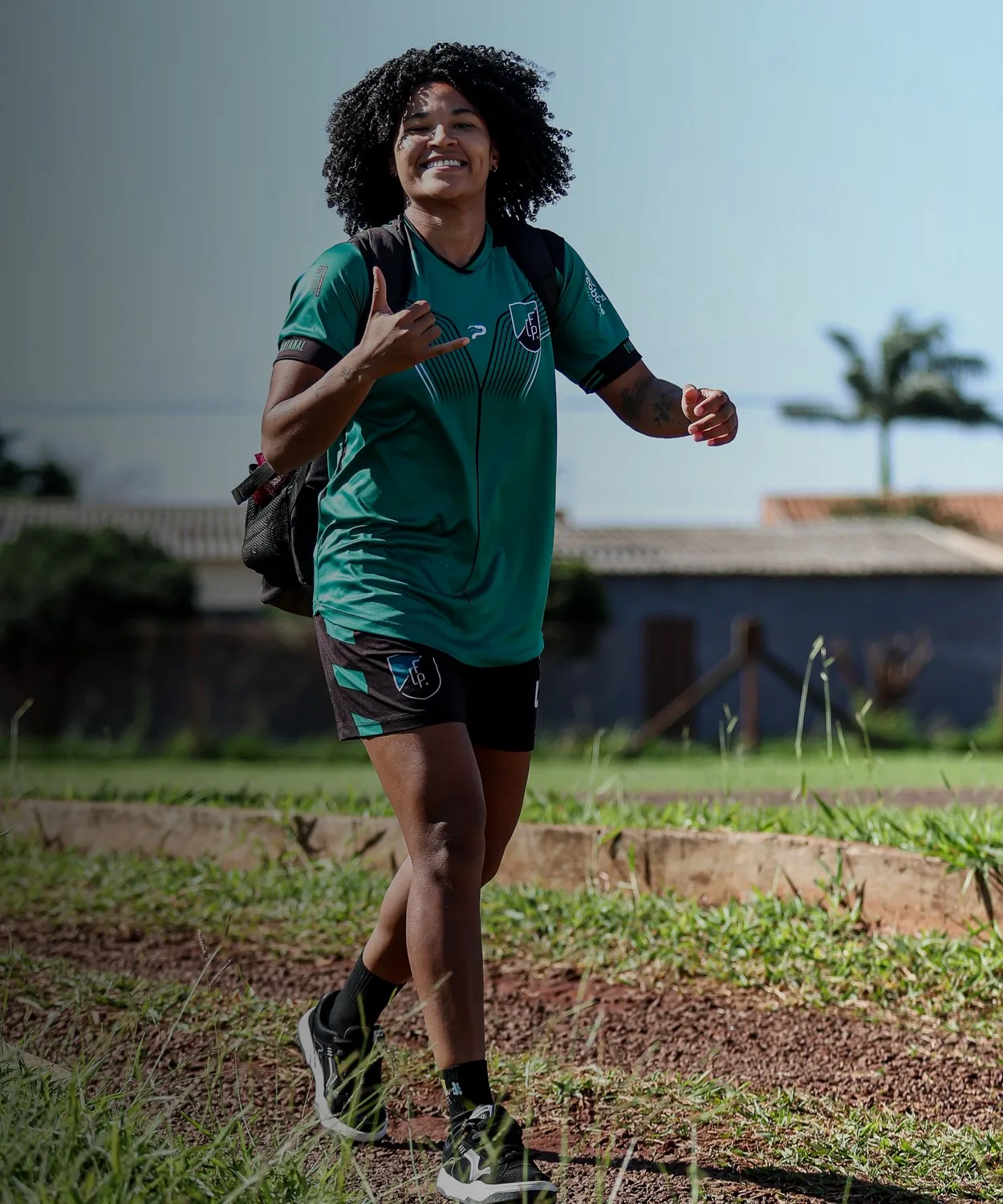 Jogadora do Pantanal de mochila, fora de campo, com a camisa do clube