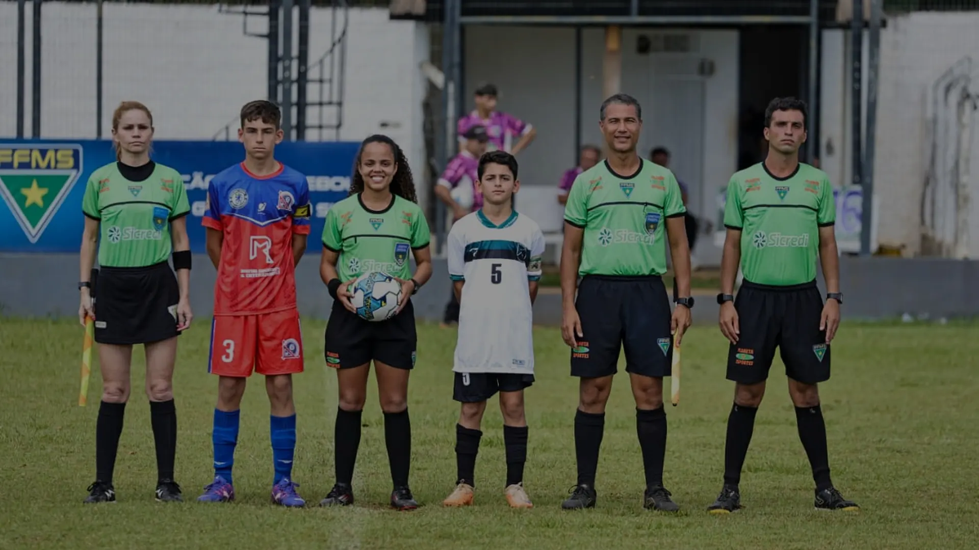 Dois times e a arbitragem perfilados no gramado antes do apito inicial